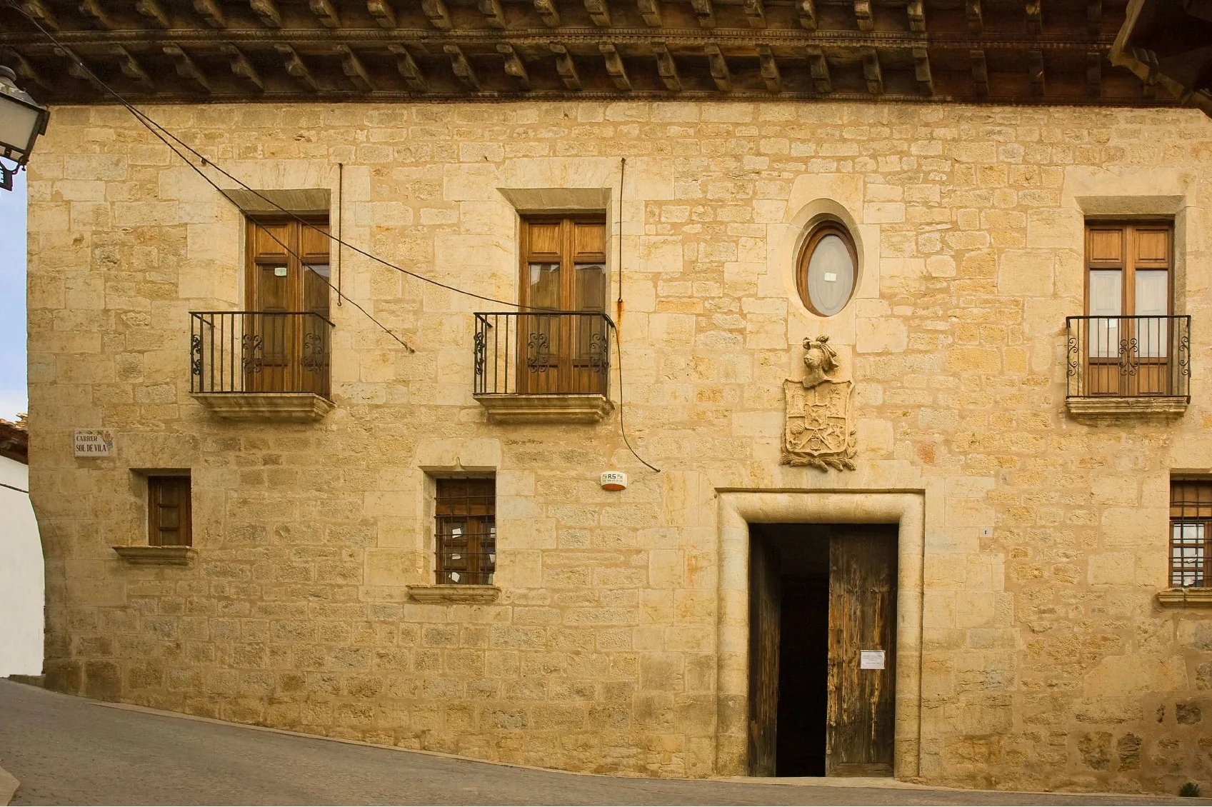 La fachada de piedra de la casa Santjoans, en Cinctorres, con el escudo sobre la puerta
